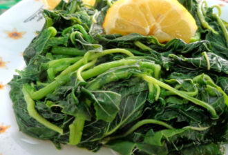 Хорта на білій тарілці з квітковим орнаментом, яка поєднується з соковитими скибочками лимона, створюючи освіжаючу страву.